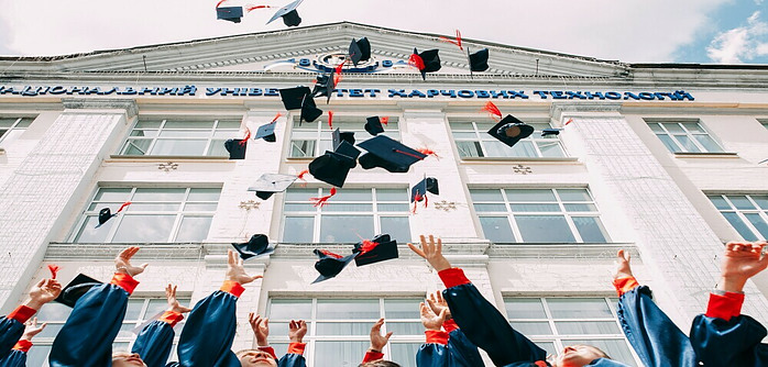 graduates throwing caps in the air