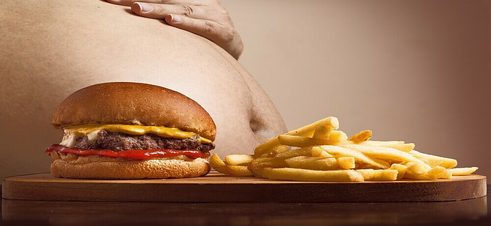 overweight person with burgers and fries